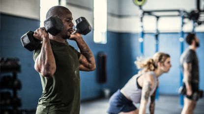Man and woman doing dumbbell HIIT workout