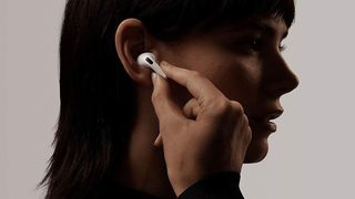 AirPods Pro worn by a woman holding the stem to control them