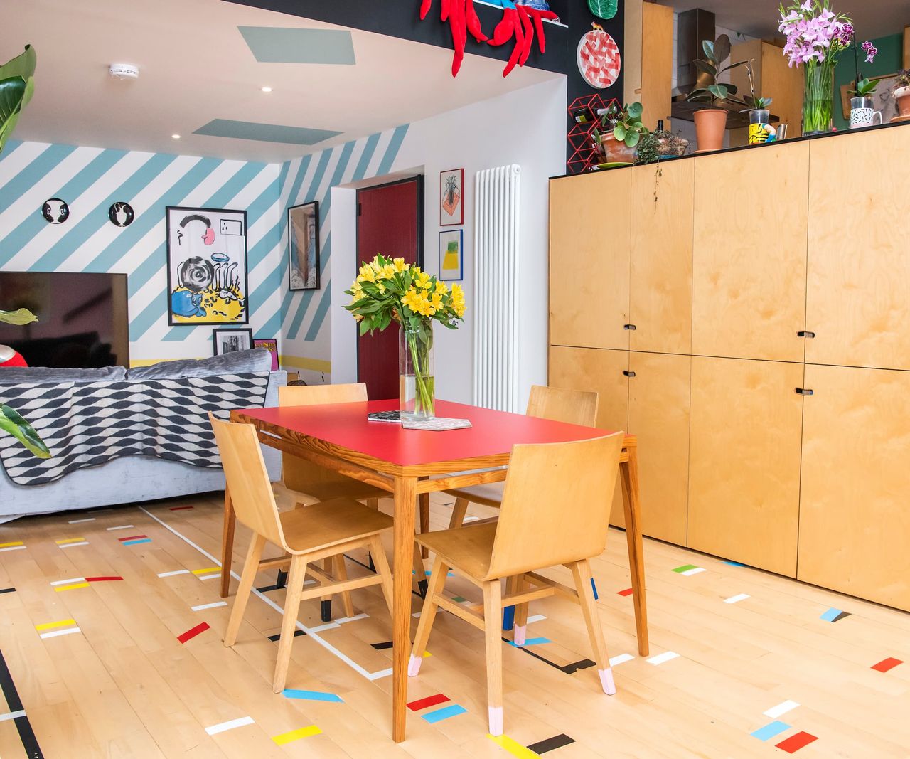 A dining area with wooden dining table and chairs with pink walls