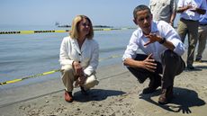 US President Barack Obama (R) speaks with LaFourche Parish President Charlotte Randolph (L) as they look over tar balls at Port Fourchon Beach, Louisiana, on May 28, 2010 before a briefing on