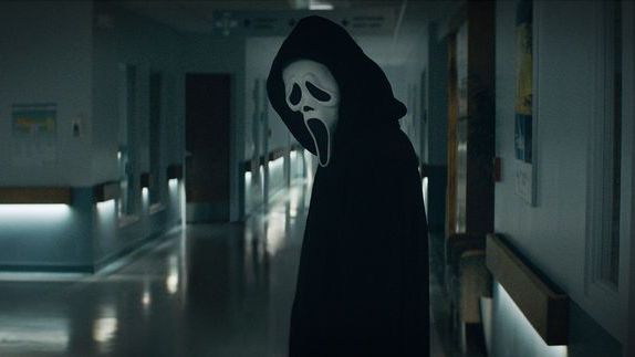 Ghostface stands in black cloak and white mask