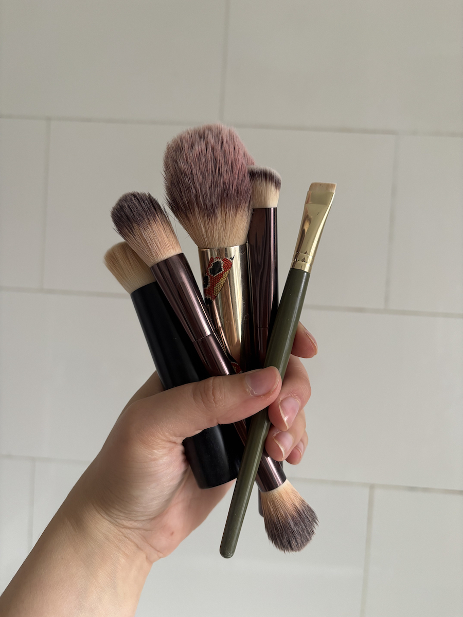 Mica Ricketts holding selection of best makeup brushes