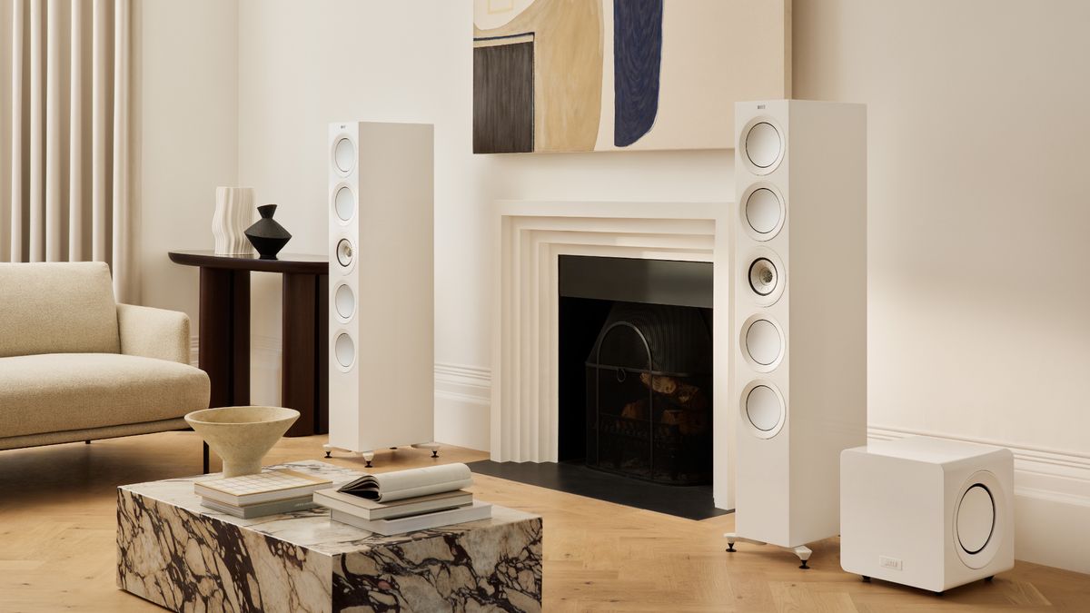 KEF KC92 in a living room next to floorstanding speakers.