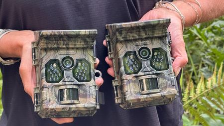 Two Wolfang WT02 trail cameras being held in a woman's hands