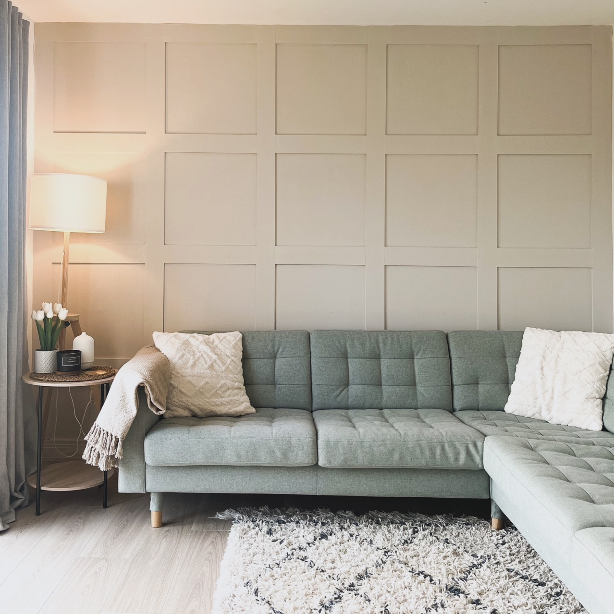 living room with green sofa and wall panelling