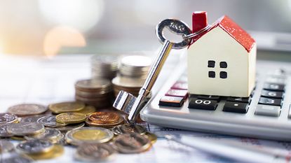 Cash, a calculator and a model house with a key