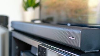 Monoprice SB-600 Dolby Atmos 5.1.2 soundbar on black TV stand in writer's home