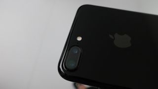 The back of a black iPhone 7 showing the camera and Apple logo