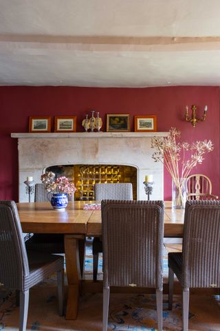 dining-room-with-raspberry-pink-accent-wall-and-grand-mantlepiece