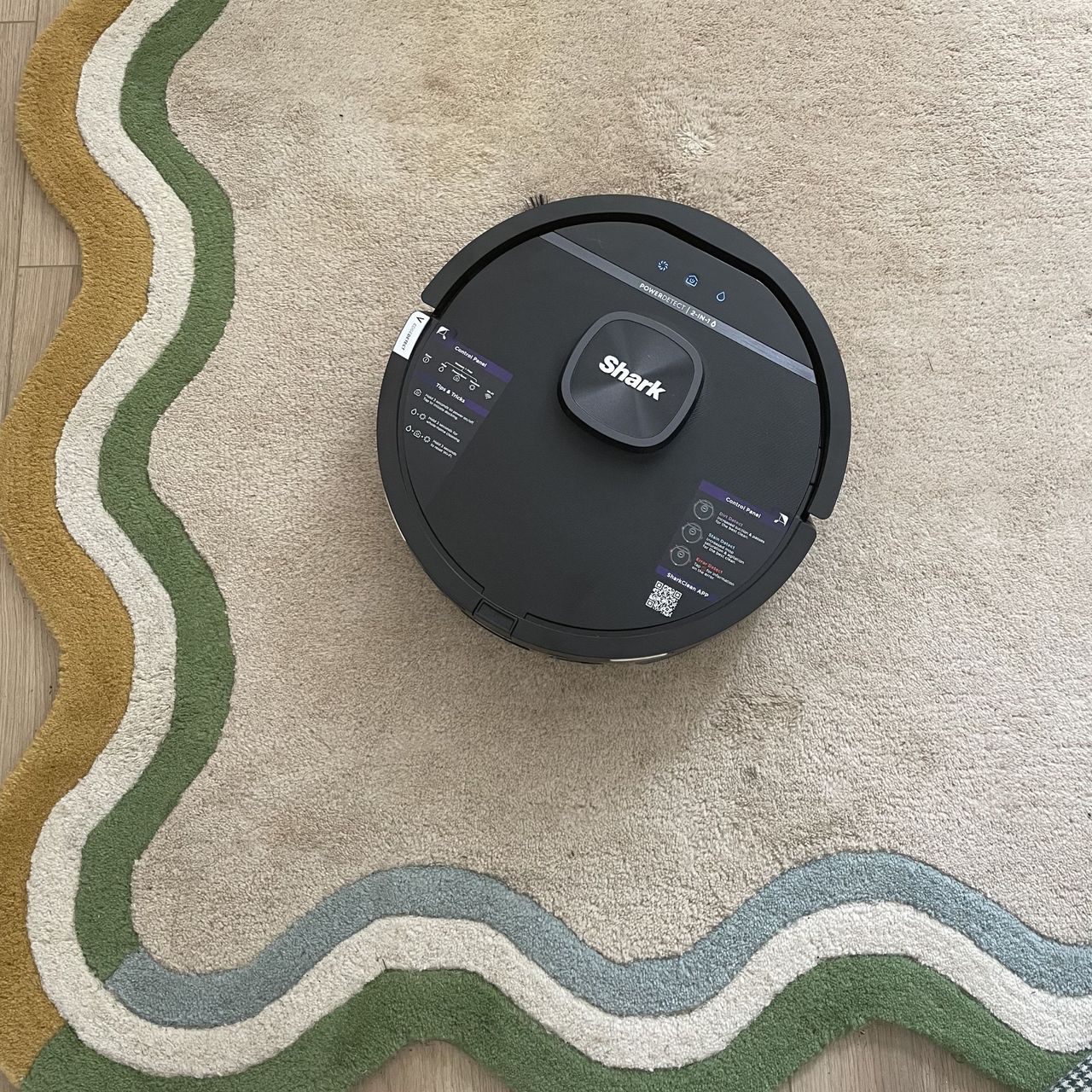 Shark PowerDetect UV Reveal 2-in-1 Vac &amp; Mop Robot Vacuum on cream rug with colourful edge