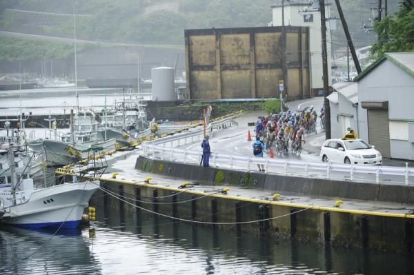 The peloton passes a small fishing port.