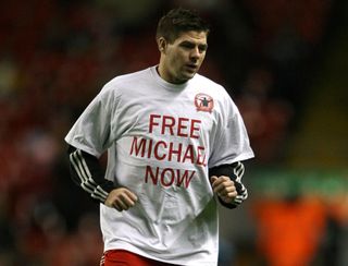 Steven Gerrard of Liverpool warms up ahead of the December 2008 Premier League match against West Ham at Anfield, wearing a shirt showing support for Michael Shields, a Liverpool supporter jailed in Bulgaria