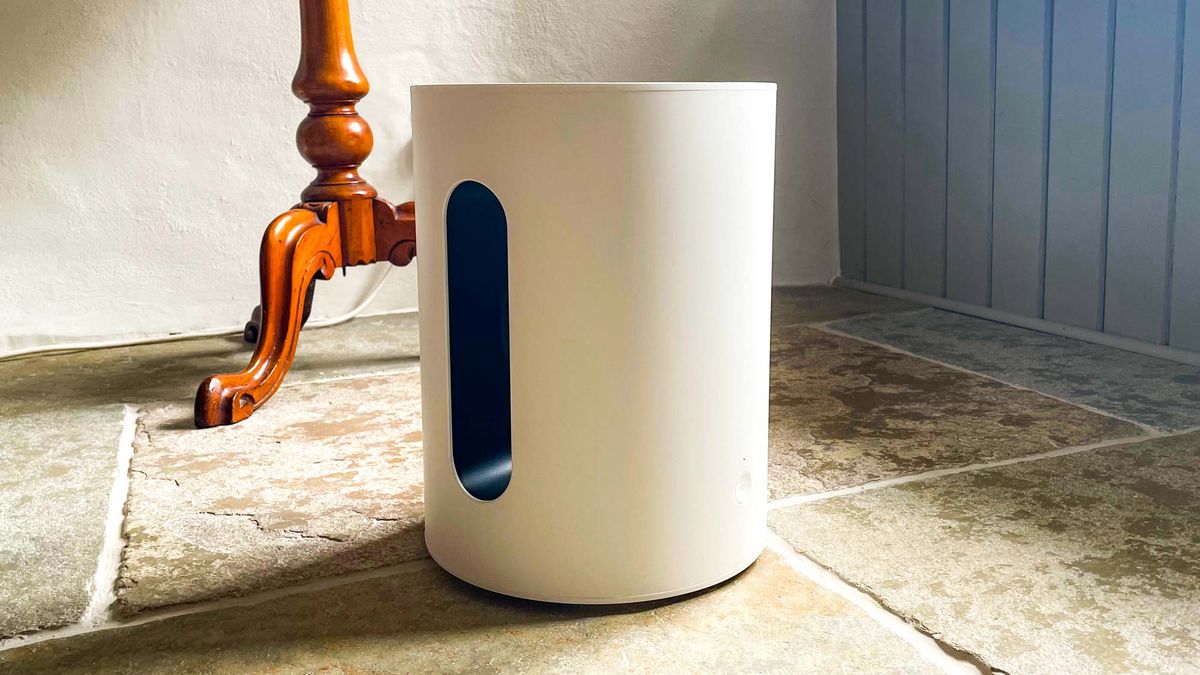 Sonos Sub Mini in white placed on a stone floor