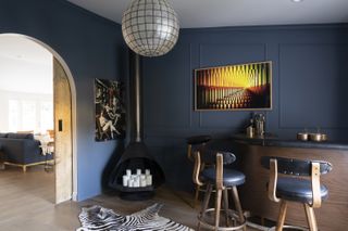 A bar room adjacent to the living room painted in deep blue