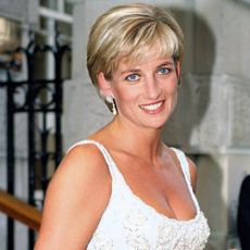 Princess Diana wearing a white plunging dress and smiling