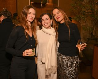 katie holmes wears a black turtleneck and tiger print slip skirt at theory dinner with zoey deutch