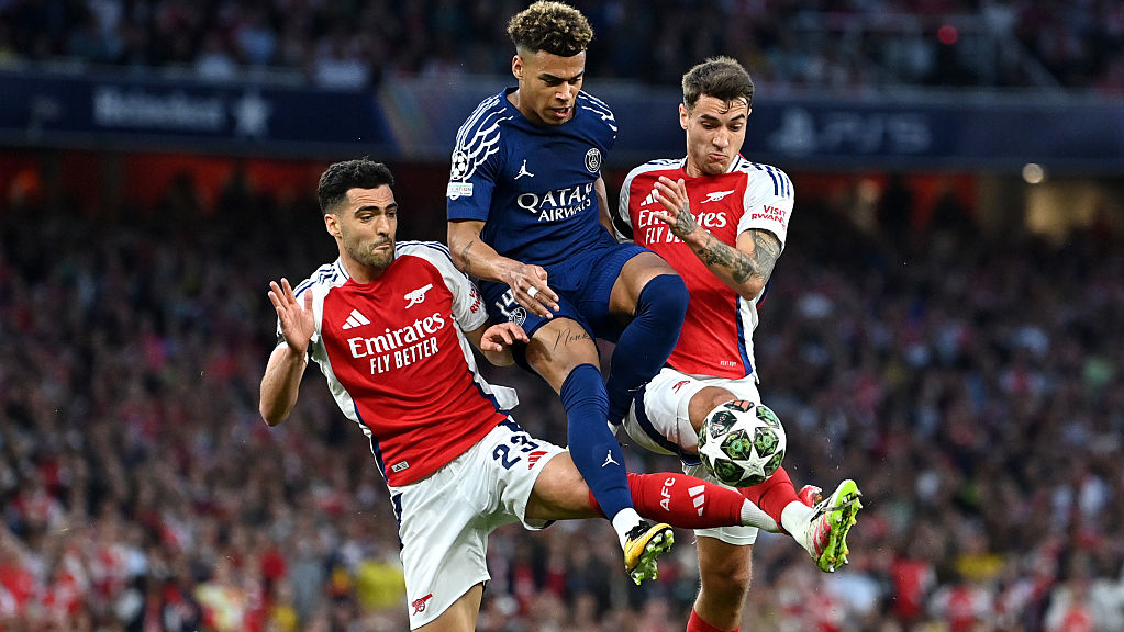 Desire Doue of Paris Saint-Germain is challenged by Mikel Merino and Jakub Kiwior of Arsenal during the UEFA Champions League 202425 Semi Final First Leg match in April 2025