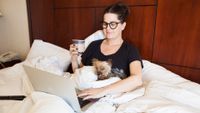 Woman and dog in hotel bed