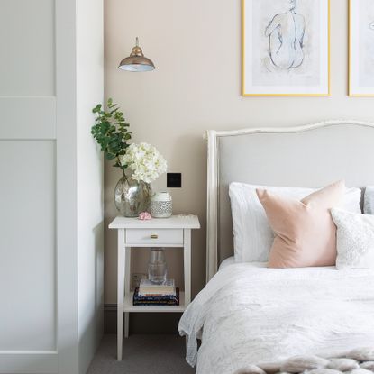 Neutral bedroom with white sheets on bed and vase on table
