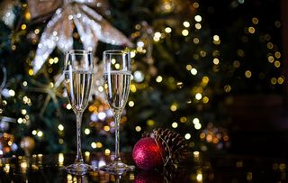 Two Champagne Glasses surrounded by Christmas Decorations