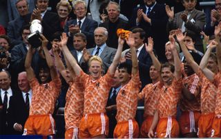 Ruud Gullit lifts the European Championship trophy as the Netherlands players celebrate their win over the Soviet Union in the final of Euro 88.