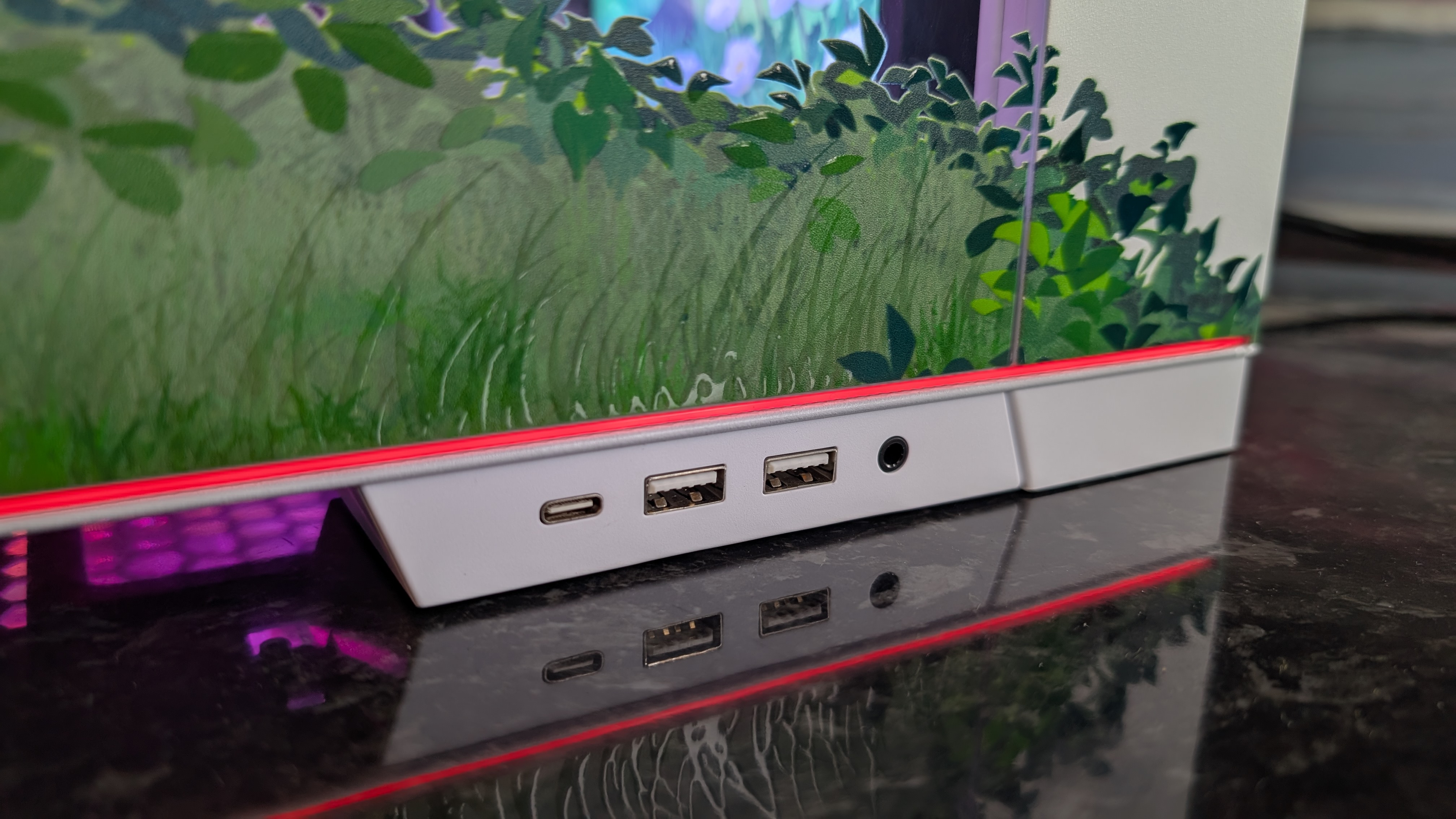 The Starforge Systems Frieren PC, photographed on a dark worktop with the RGB lighting switched on.