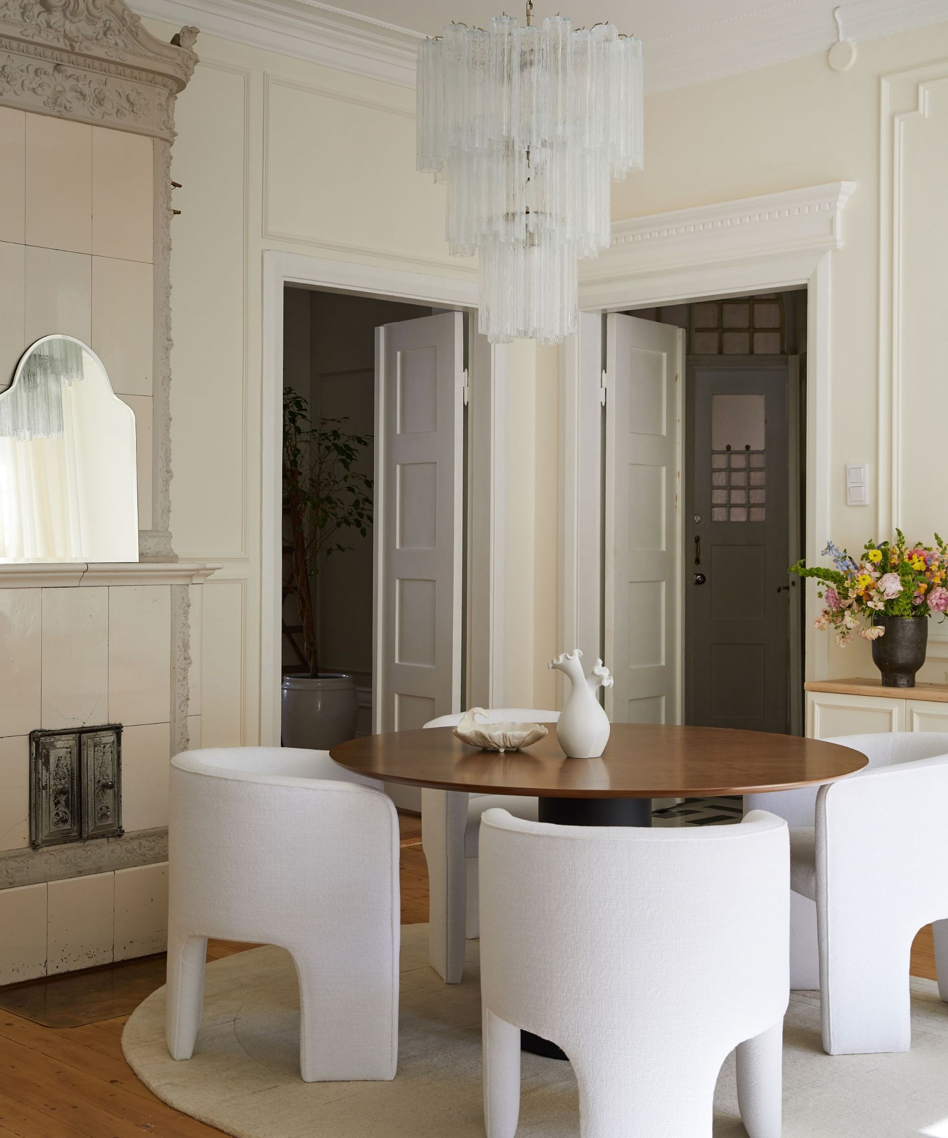 White chairs, white rug, black wooden table, white shelves