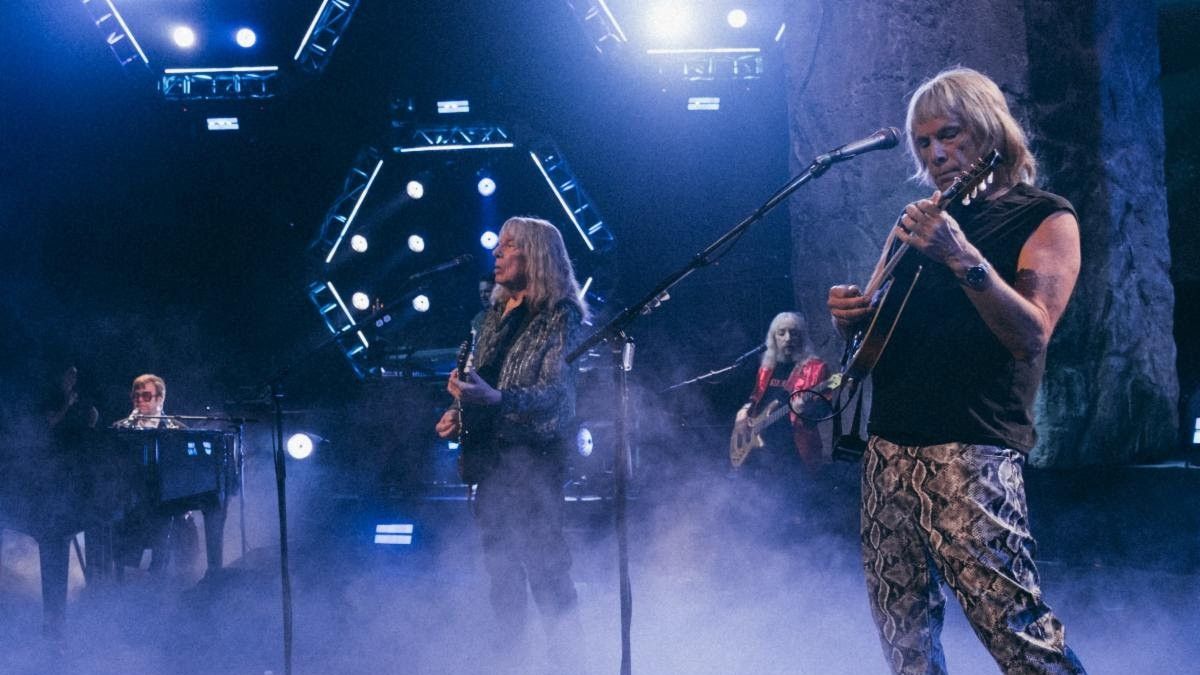 Elton John at piano, Christopher Guest and Michael McKean playing guitars on stage in Spinal Tap 2: The End Continues