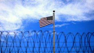 Flag, Blue, Daytime, Flag of the united states, Wire fencing, Cloud, Atmosphere, Line, Mesh, Pattern,