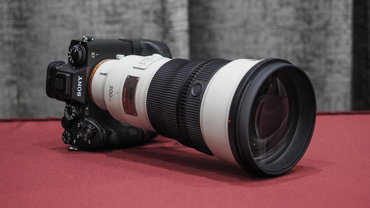 Sony FE 300mm f/2.8 GM OSS lens on a red table with grey curtains