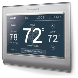 A silver smart thermostat with black screen