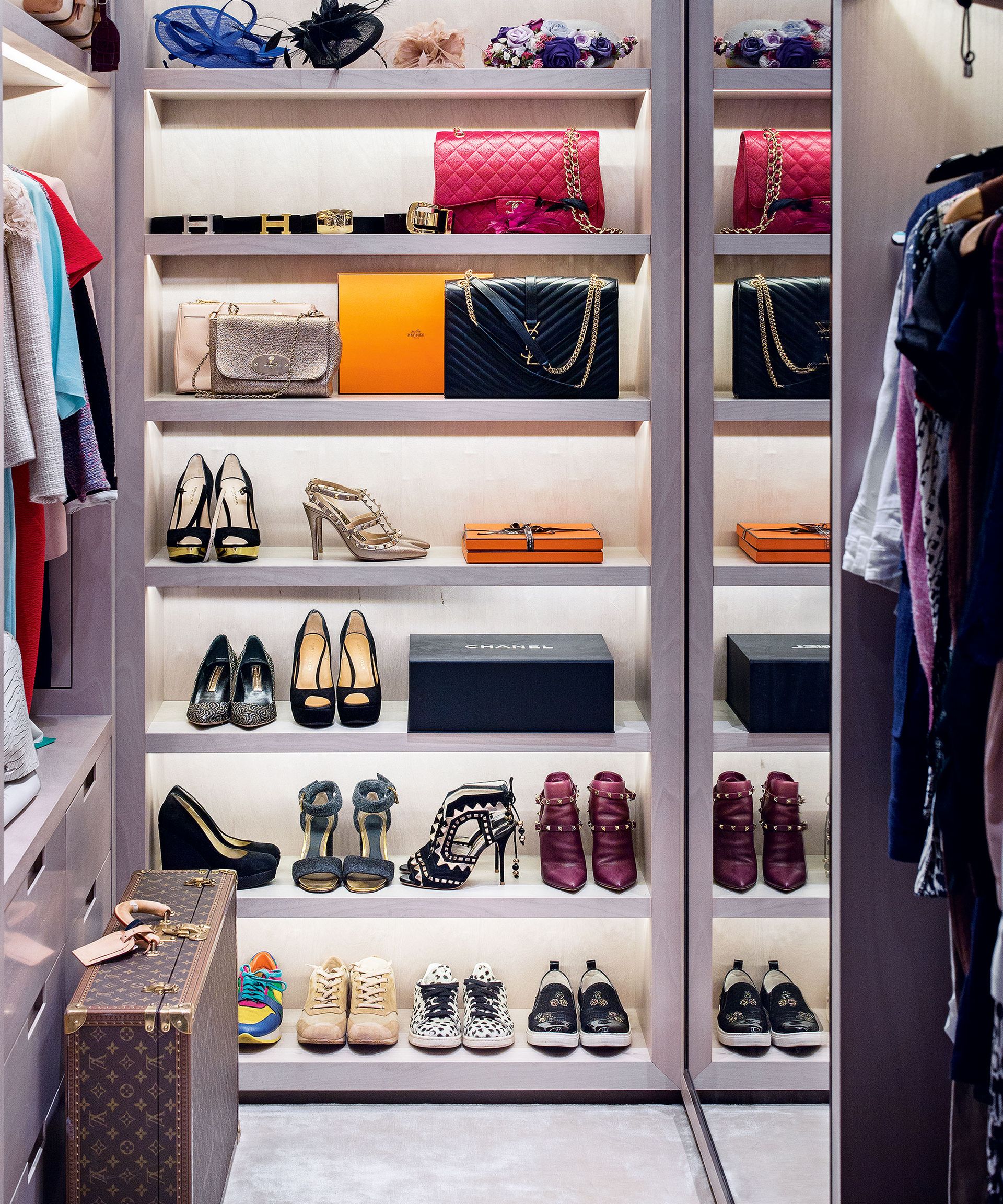 Floor to ceiling open small bedroom storage with shoes and handbags.