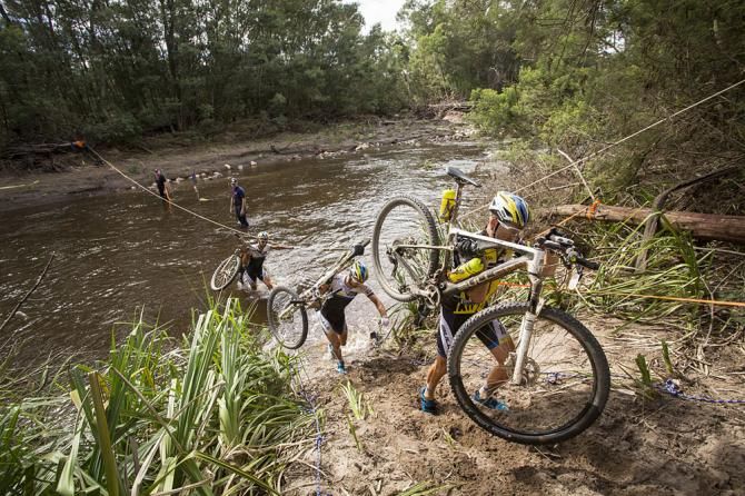Team Bulls cross a river together during stage 3