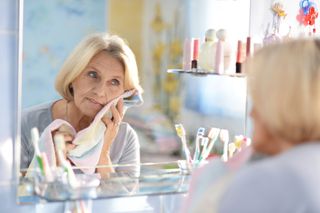 An older woman looks in the mirror