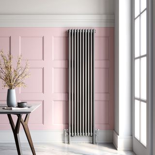 tall metal column radiator on pink wall panelling