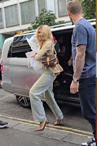 Zendaya leaves a fan wearing wide leg jeans and a pair of louboutin kate pumps while carrying a louis vuitton bag