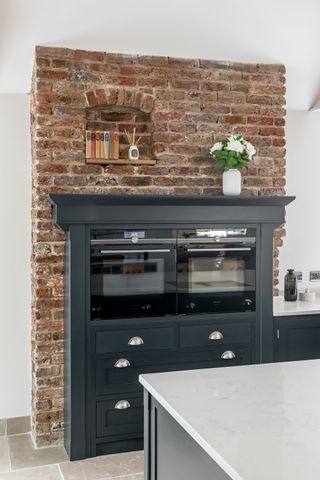 brick fireplace with bespoke cabinetry and ovens