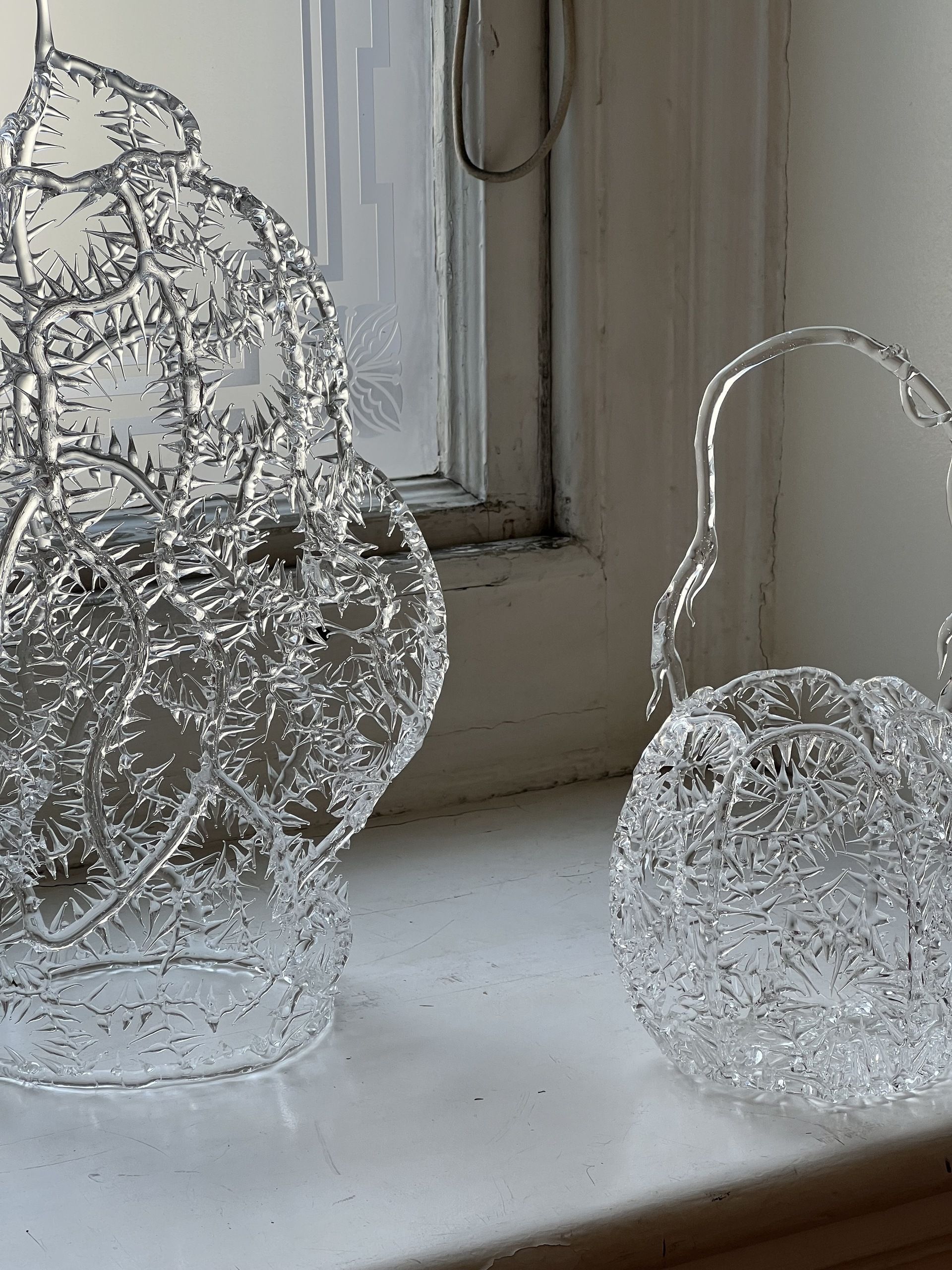 Close-up image of two vases made out of a delicate, clear plastic that looks like ice.