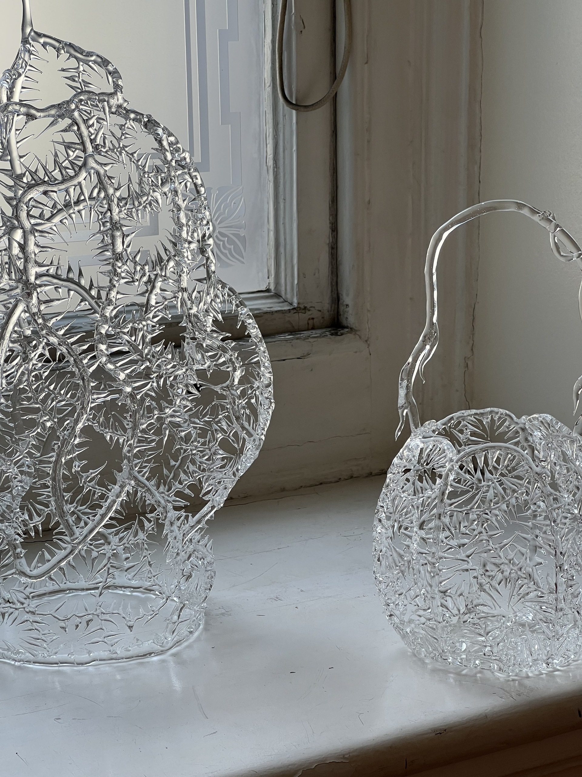 Close-up image of two vases made out of a delicate, clear plastic that looks like ice.