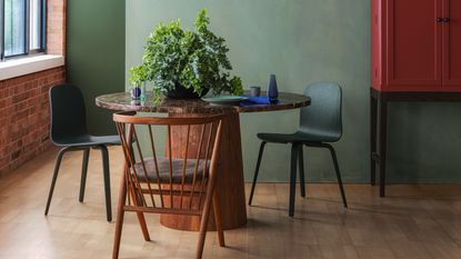 Paint colors that go with natural wood: Dark wood dining table and chairs against green wall