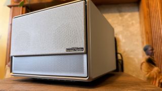 A gold-coloured XGIMI Horizon Ultra 4K projector in front of a fireplace