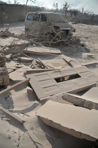 A car covered in volcanic ash sits amongst surrounding damage after Mount Merapi volcano erupted the night before in the village of Pakem in Sleman, Yogyakarta province.