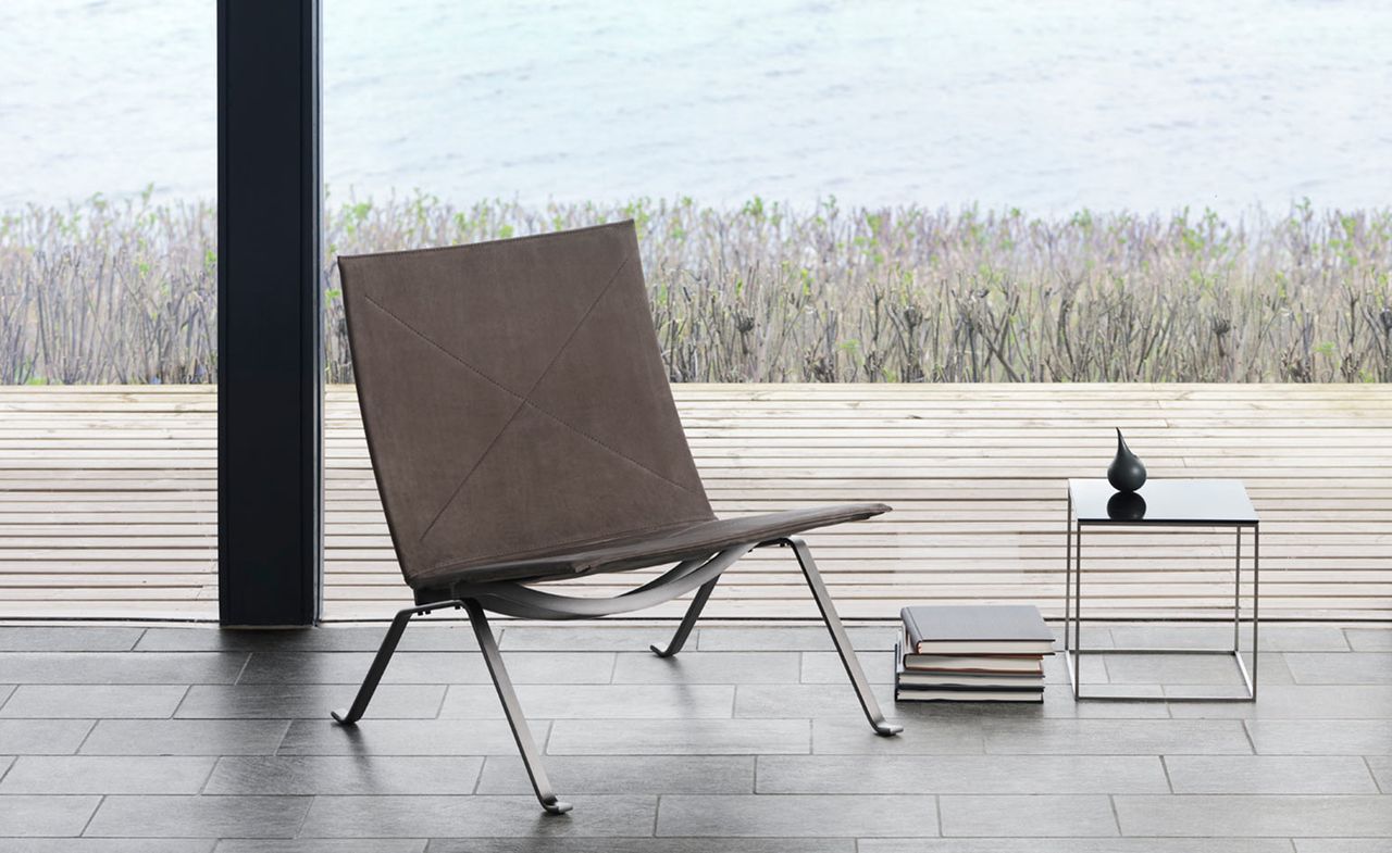 Brown chair next to a stack of books and a small table