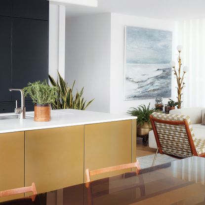 Gold and white kitchen countertop, armchair, hanging wall art