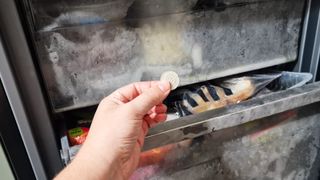 Holding a coin in front of a freezer