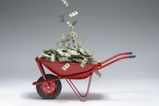 dollars falling into a wheelbarrow
