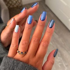 a person wearing gradient blue chrome nails