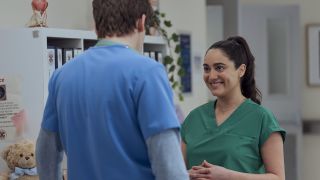 Amara talking to Asher inside Sacred Heart in Scrubs