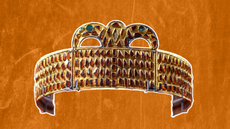 a gold and garnet crown against an orange background