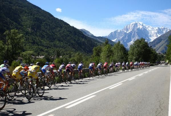 The peloton goes uphill in pursuit of the break.
